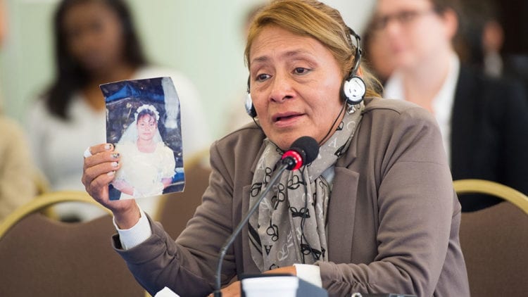 Woman holds up photo of Paola, her daughter, in court
