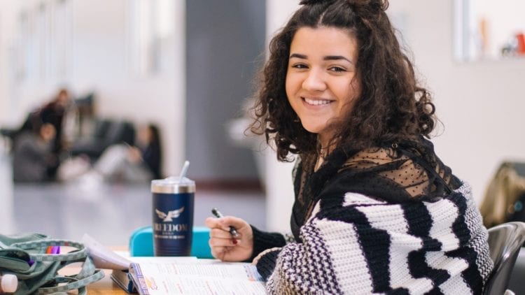 teenage girl smiling doing schoolwork