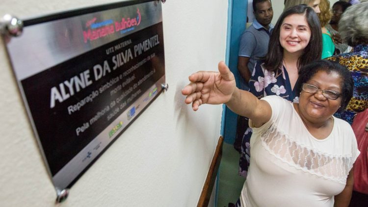 Alyne Pimentel pointing to a sign in memory of her daughter