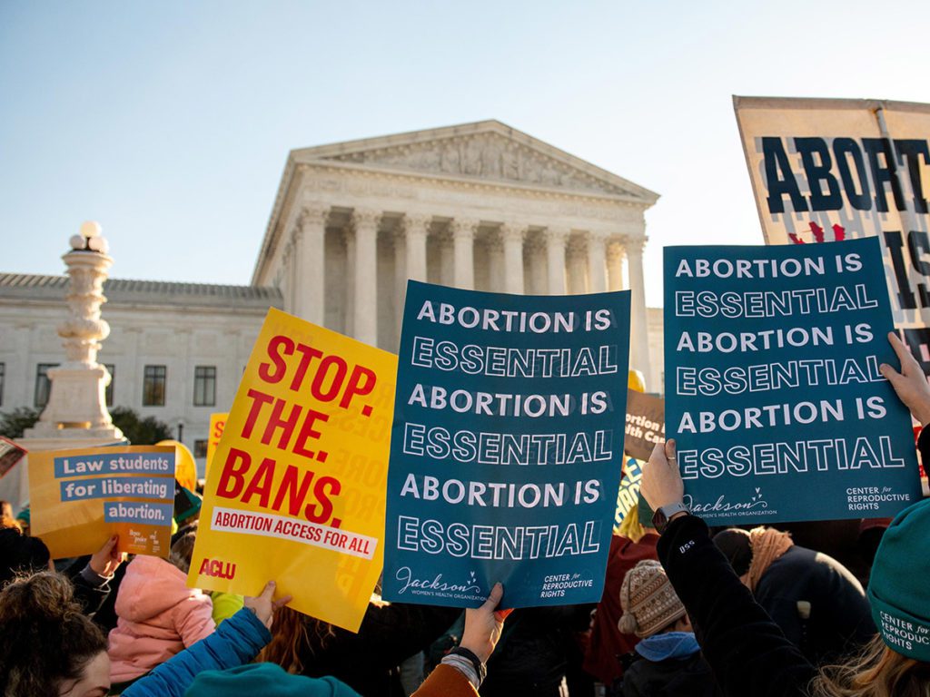 protest signs in front of the Supreme Court building saying Abortion is Essential