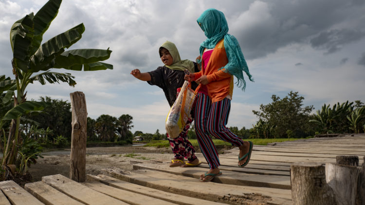 Villagers cross a wooden bridge in Mamasapano, Philippines