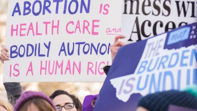 rally with abortion sign and texas map