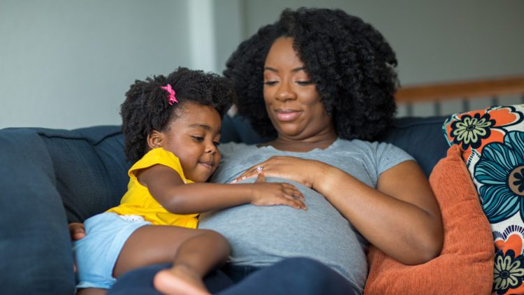 Pregnant black woman with daughter