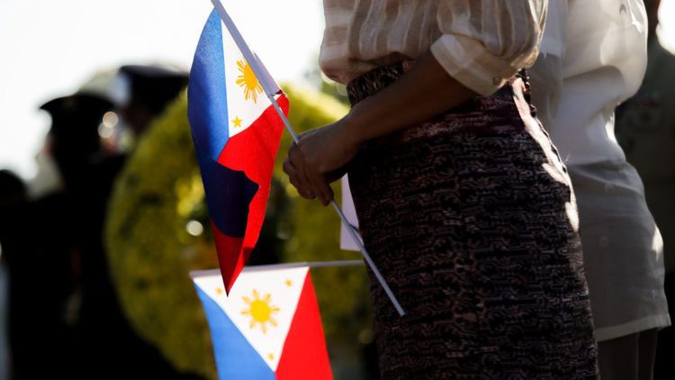 woman holding a Philippines flag