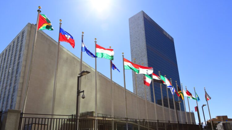 United Nations Headquarters with waving flags in New York, USA