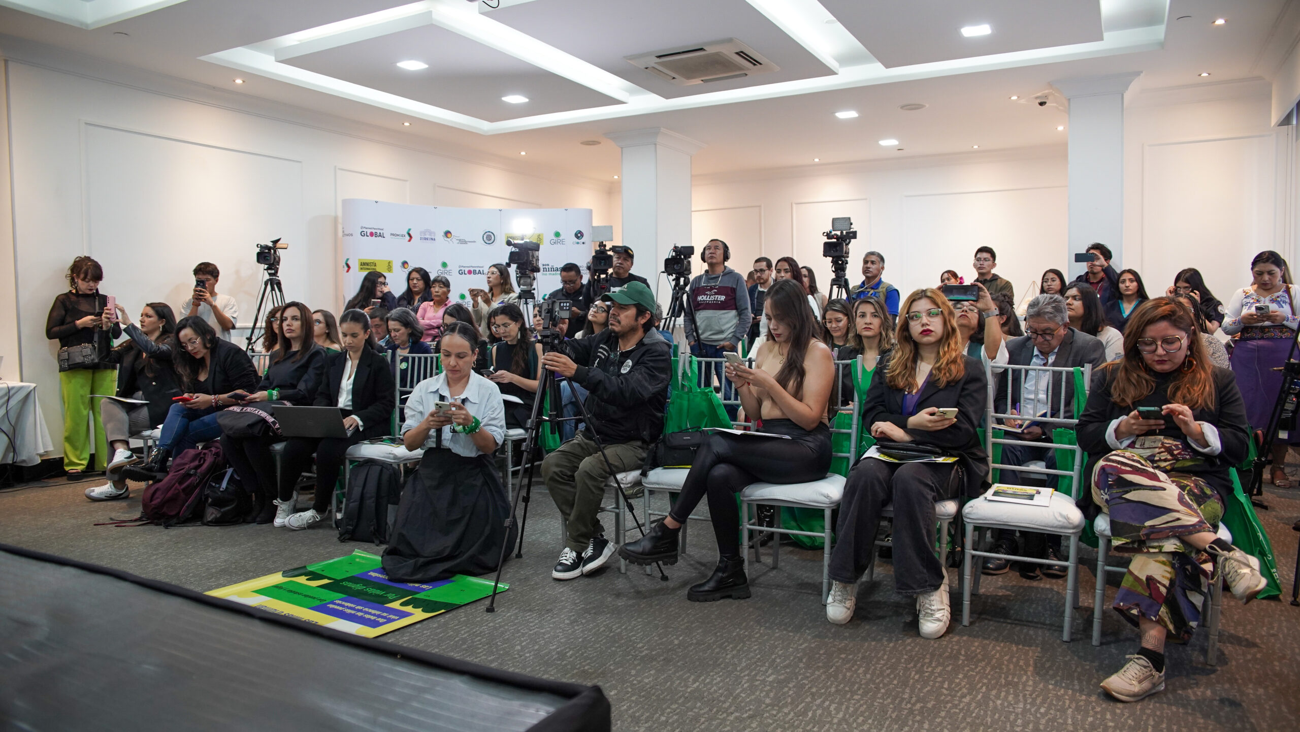 Audience members and press watching the panel