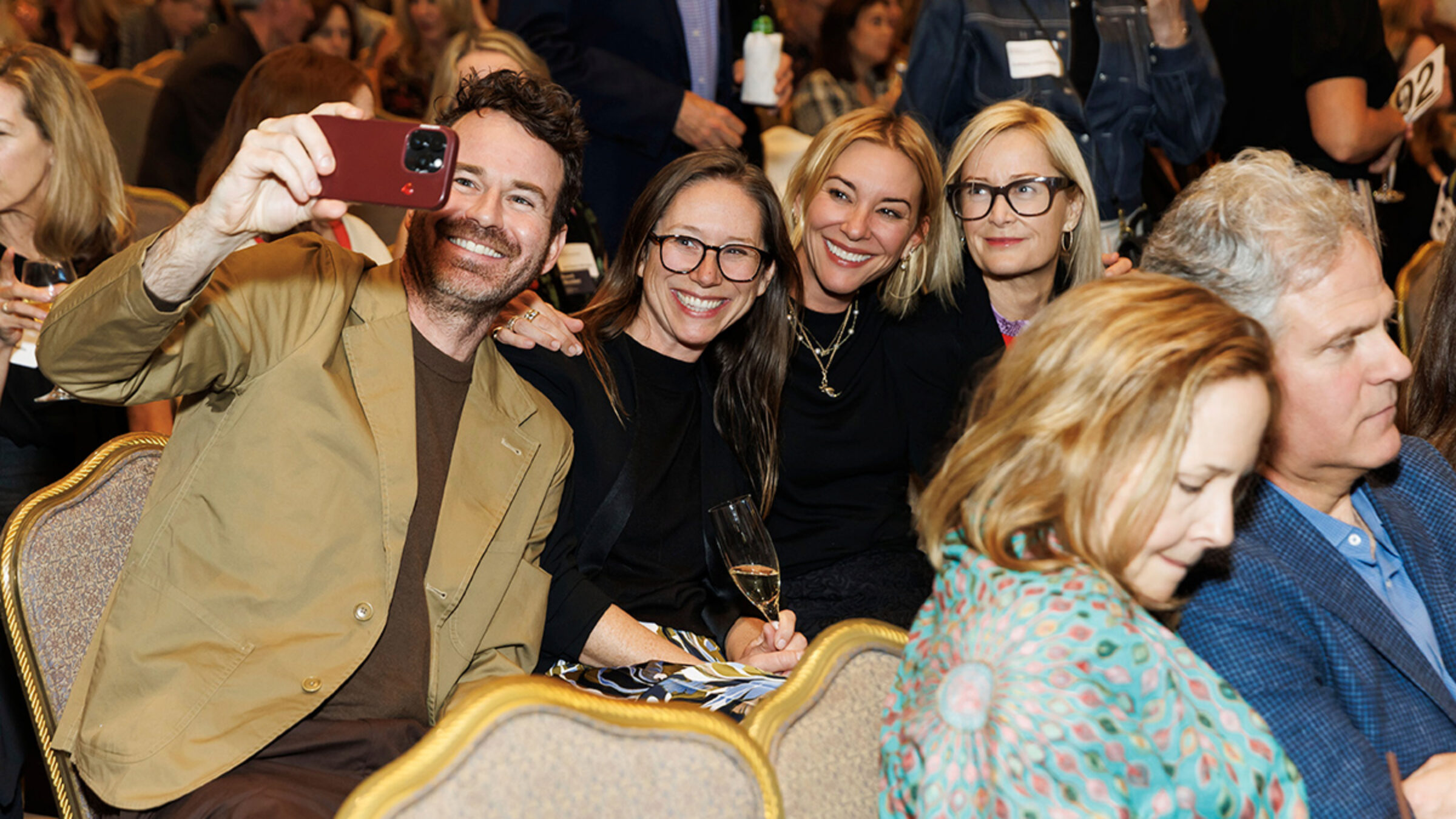 San Francisco Benefit 2026 - a man taking a photo with three women in a crowd