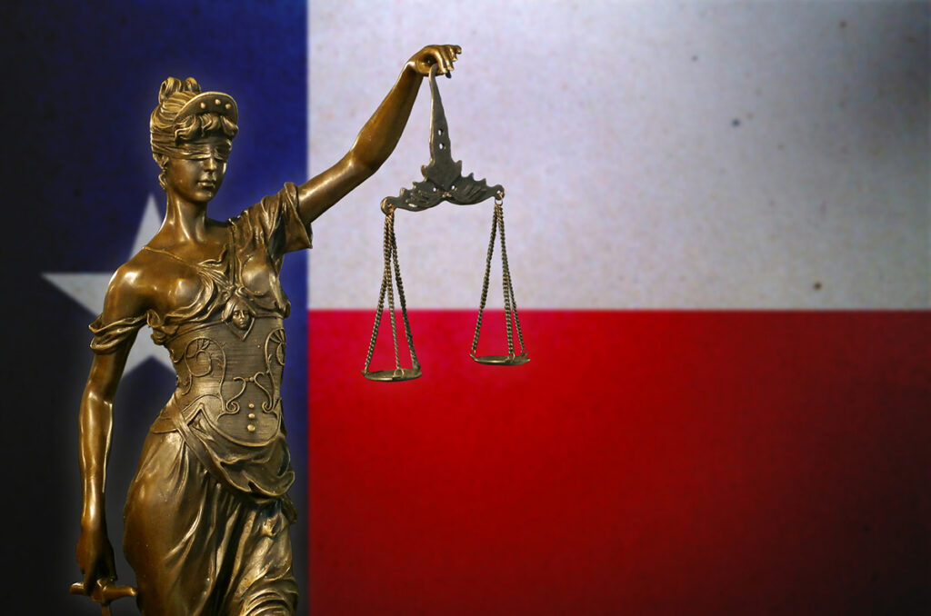Lady Justice in front of a Texas flag