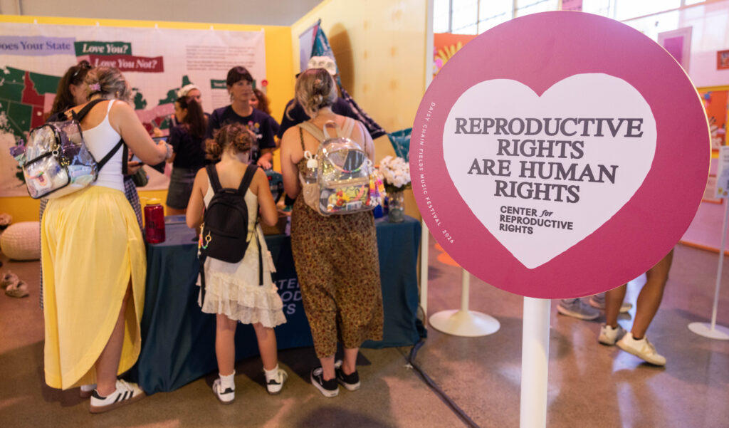Mom, daughter, and friend at Center for Reproductive Rights' booth at Daisy Chain Fields music festival.